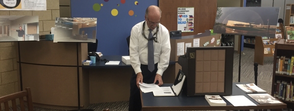 Ever the servant leader, Dr. Davis is captured preparing for a community presentation with images behind him of the evolving and completed Hillside Elementary School.